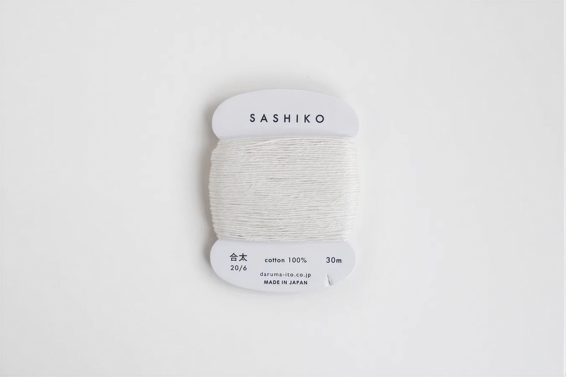 A spool of white thread labeled "SASHIKO" against a white background.
