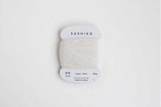 A spool of white thread labeled "SASHIKO" against a white background.