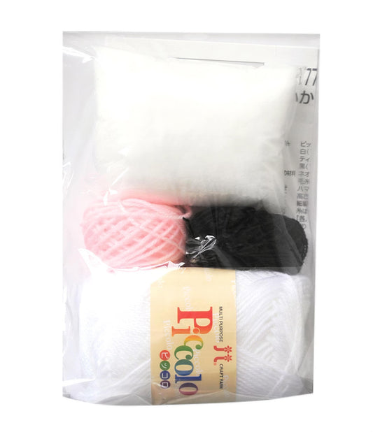 A package containing various craft supplies, including yarn, a ball, and a black object.