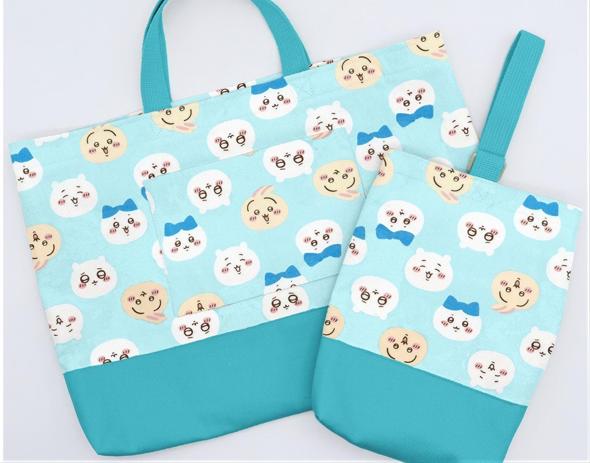 A blue tote bag with a pattern of cartoon cat faces and a matching blue handle.