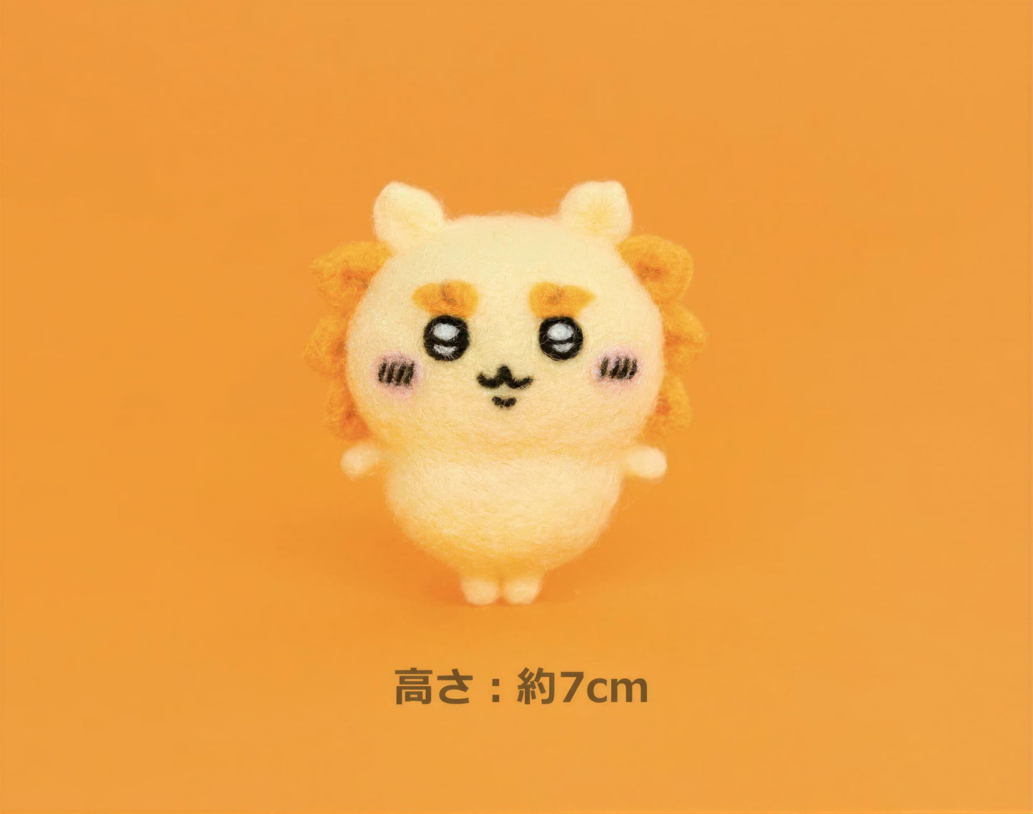 A small, cute, and colorful plush toy with a smiling expression is shown against an orange background.