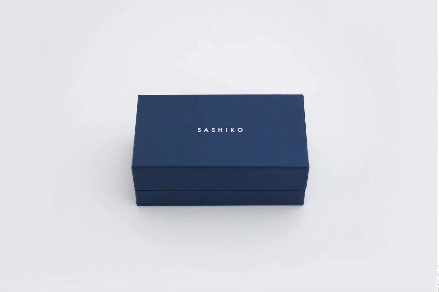 A navy blue rectangular box with the word "SASHIKO" printed on it.