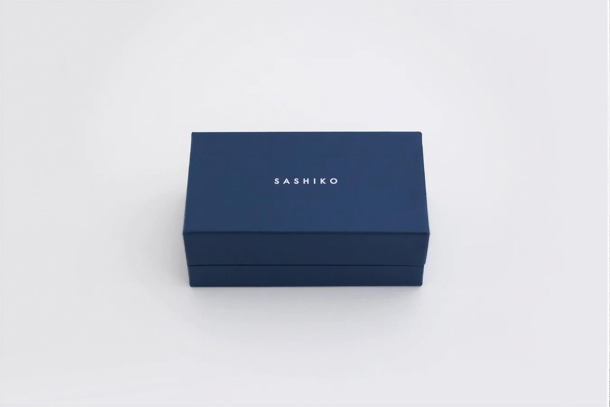 A navy blue rectangular box with the word "SASHIKO" printed on it.