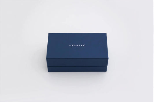 A navy blue rectangular box with the word "SASHIKO" printed on it.
