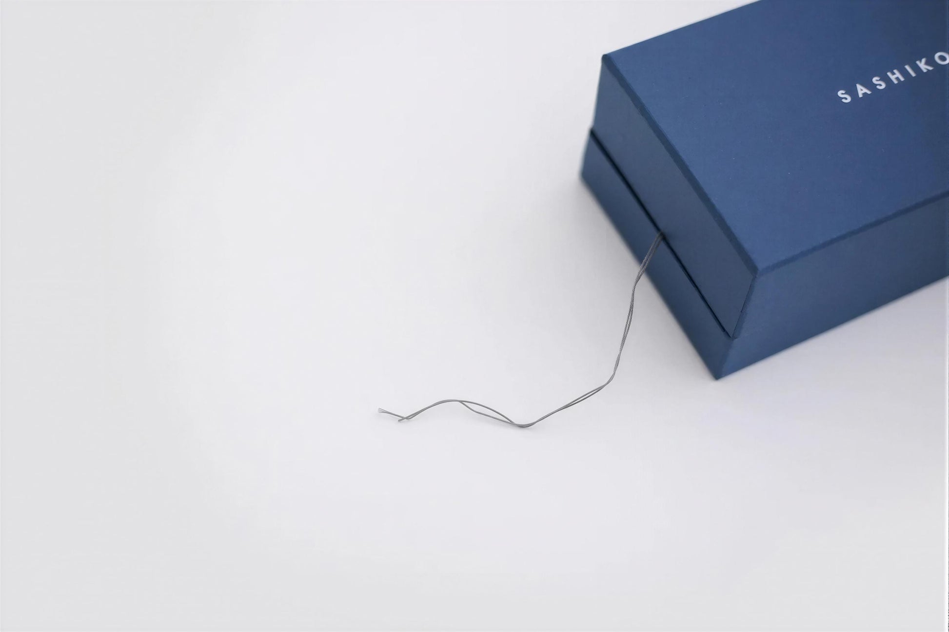 A blue box with a wire trailing off the edge, set against a plain white background.