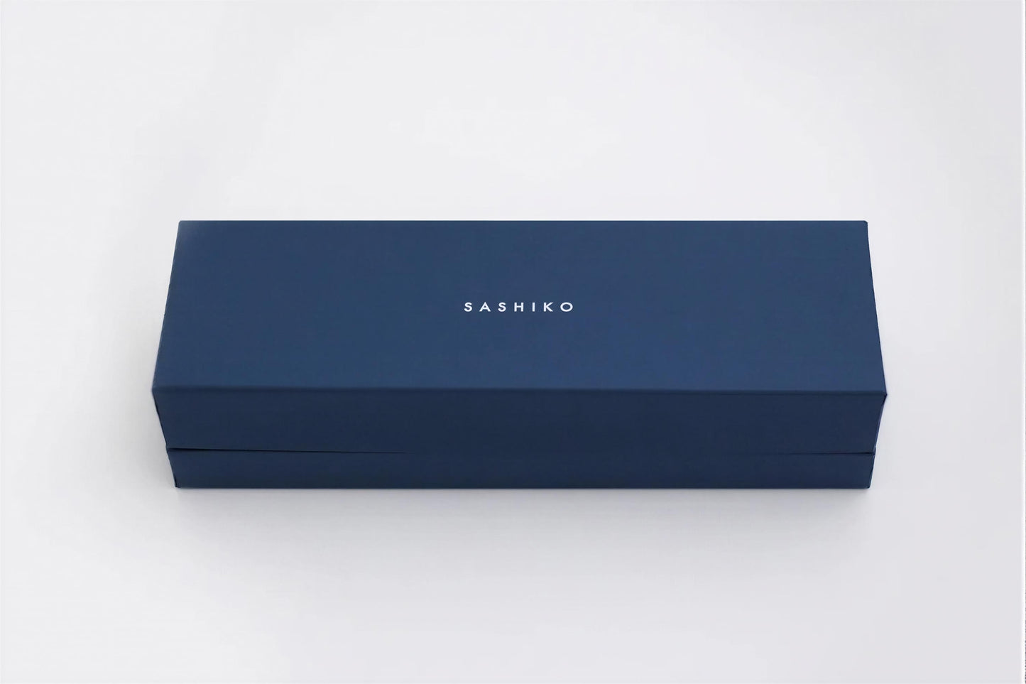 A navy blue rectangular box with the word "SASHIKO" printed on it.
