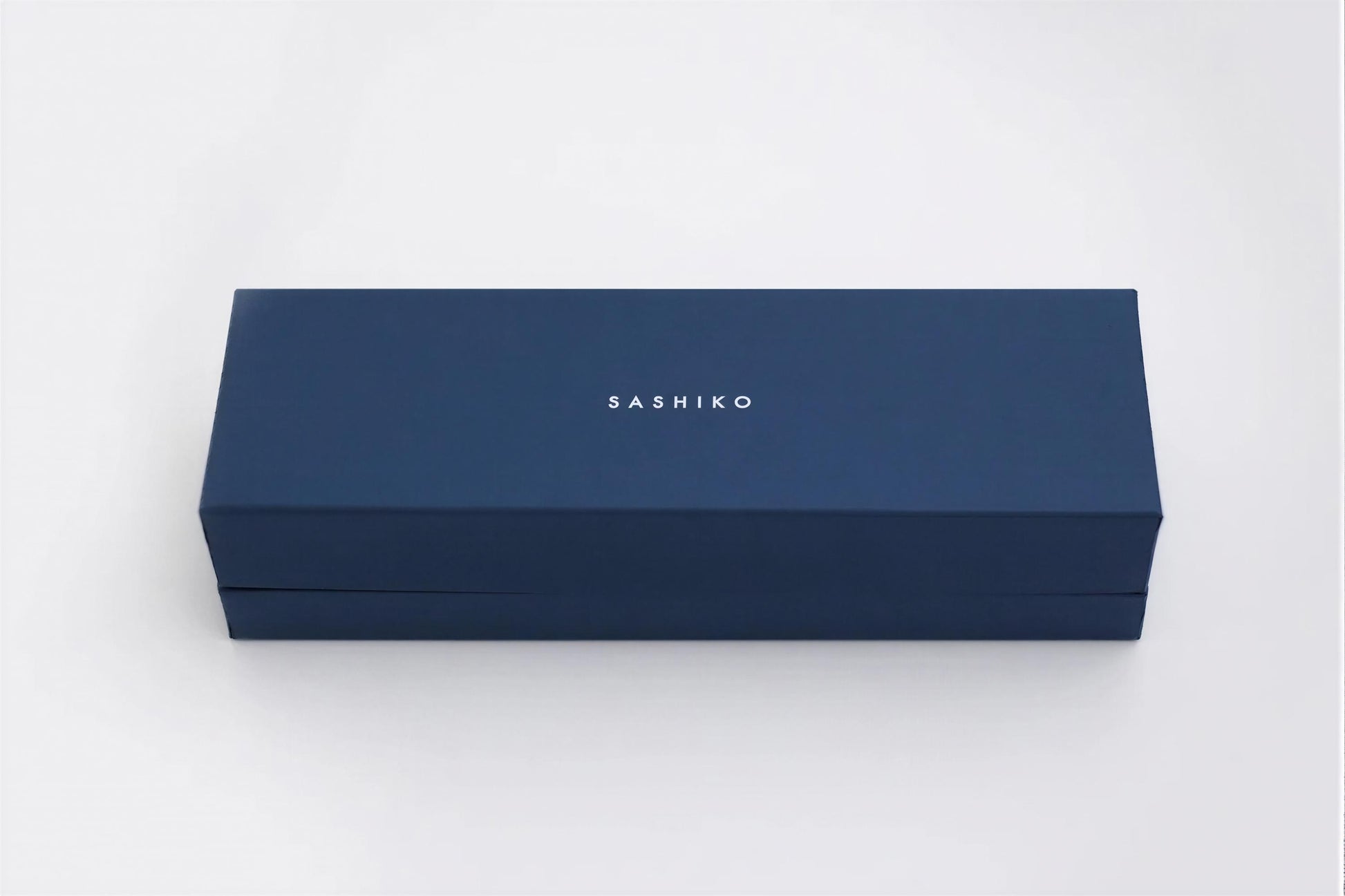 A navy blue rectangular box with the word "SASHIKO" printed on it.