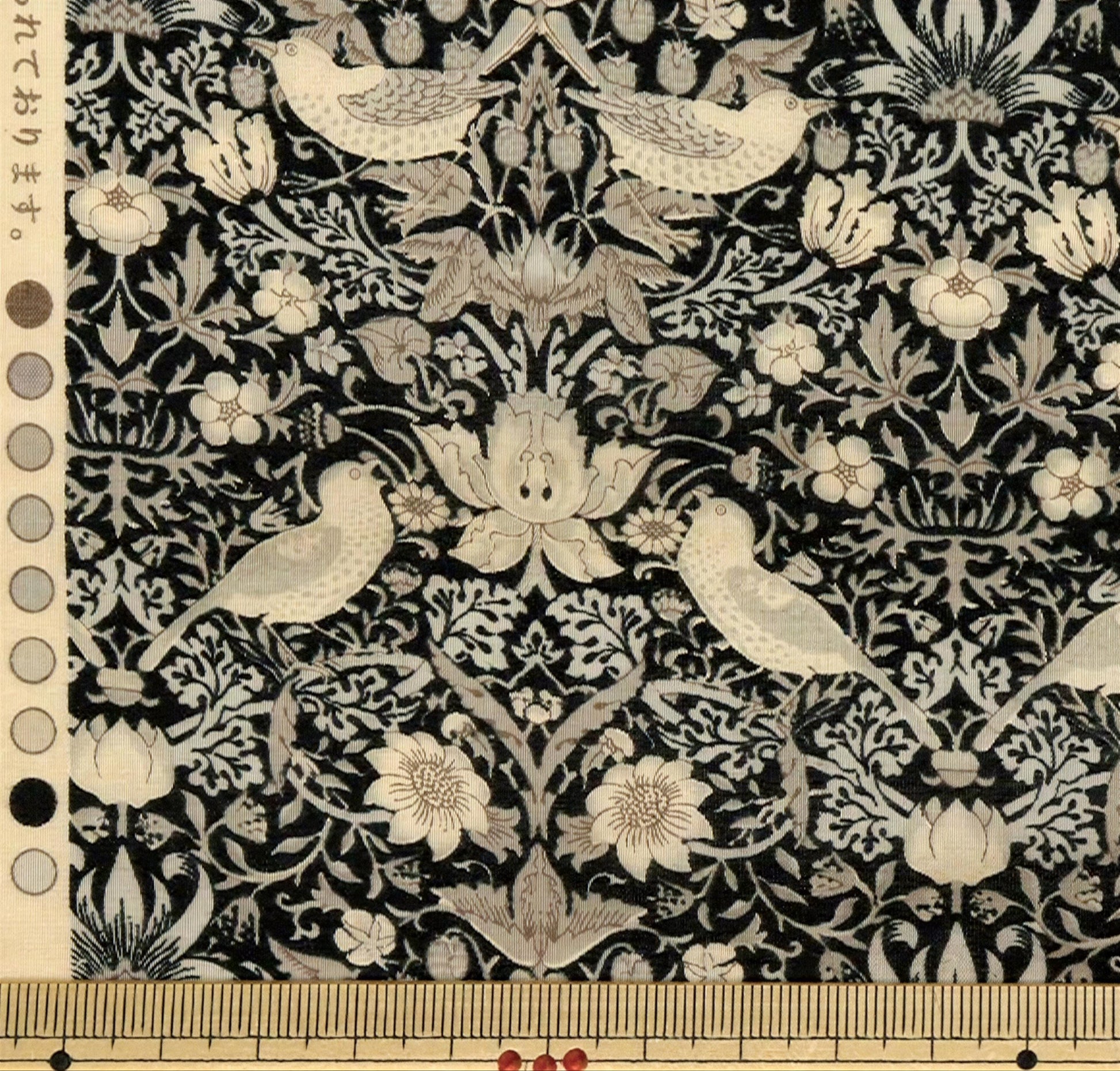 a detailed and intricate black and white floral pattern with various birds and flowers throughout the design.