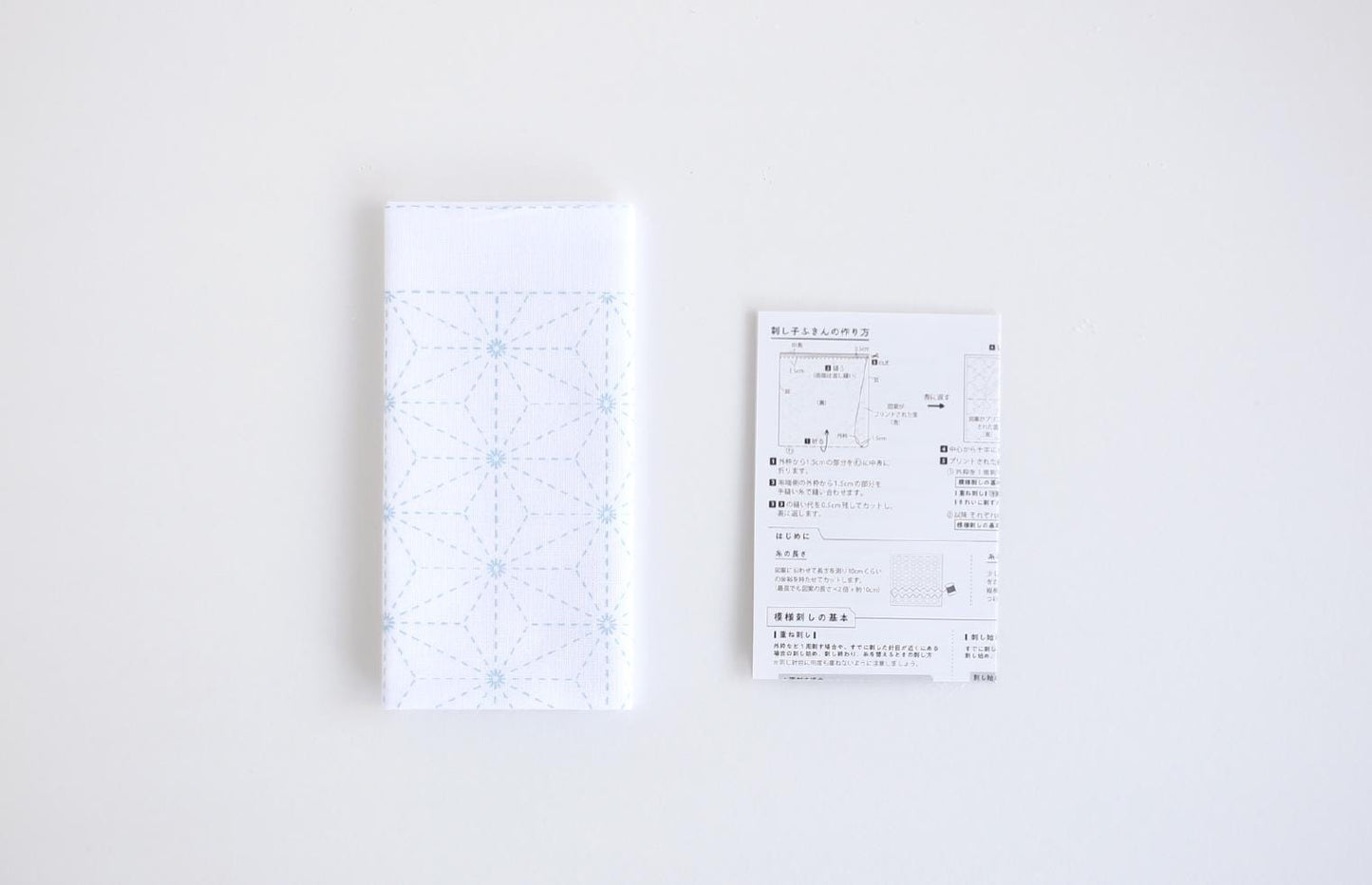 a white napkin with a blue geometric pattern and a white receipt with Japanese text.