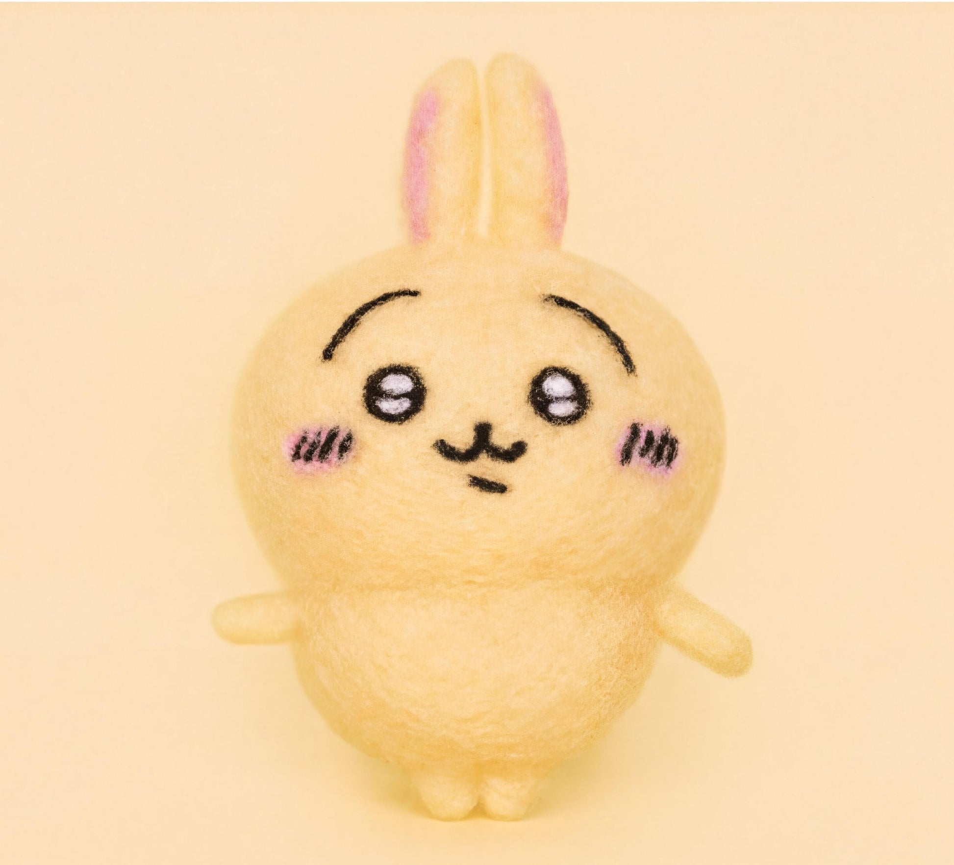A cute, yellow plush rabbit with a pink nose and ears, with a small smile on its face, is the main subject of the image.