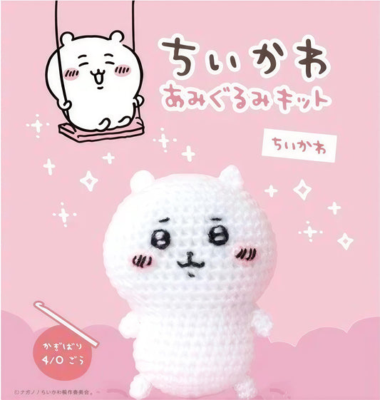 The image is a crocheted doll with a cute face, sitting on a pink background with a small white character on a swing.