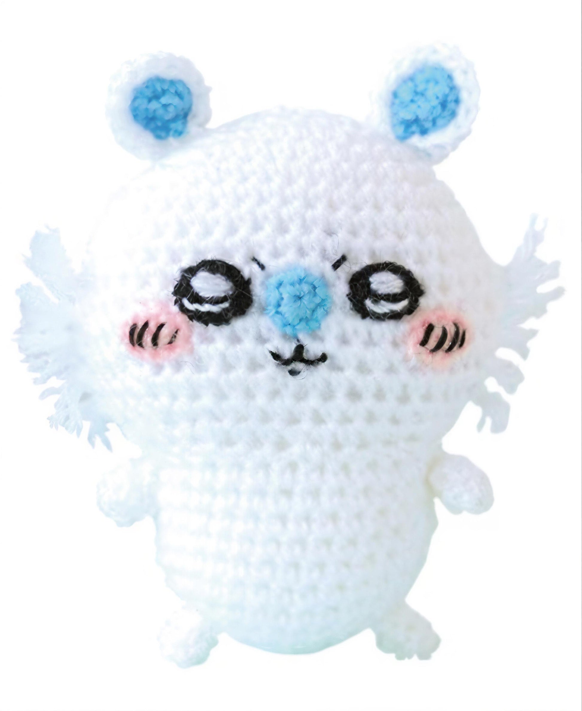 A white crocheted toy with blue accents, resembling a small animal or creature.