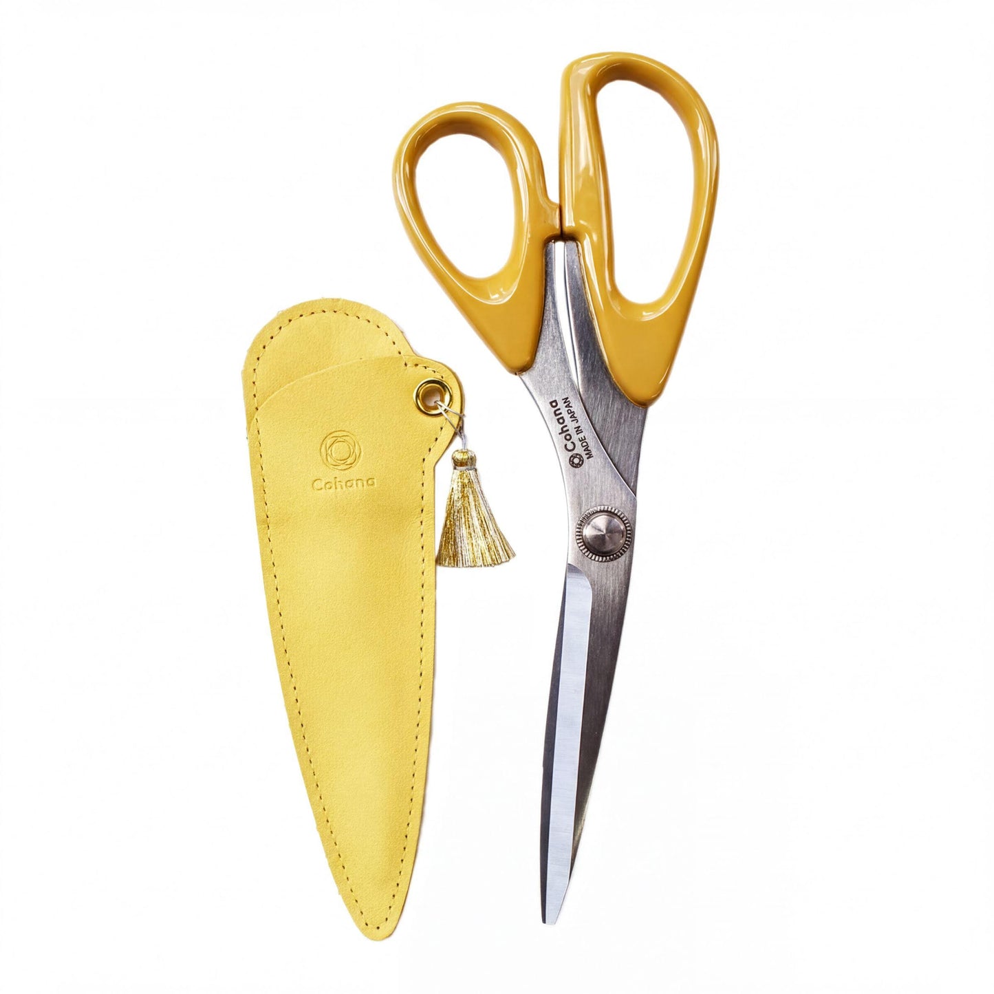 A pair of yellow scissors with a yellow tassel attached to the handle, placed next to a yellow leather case.