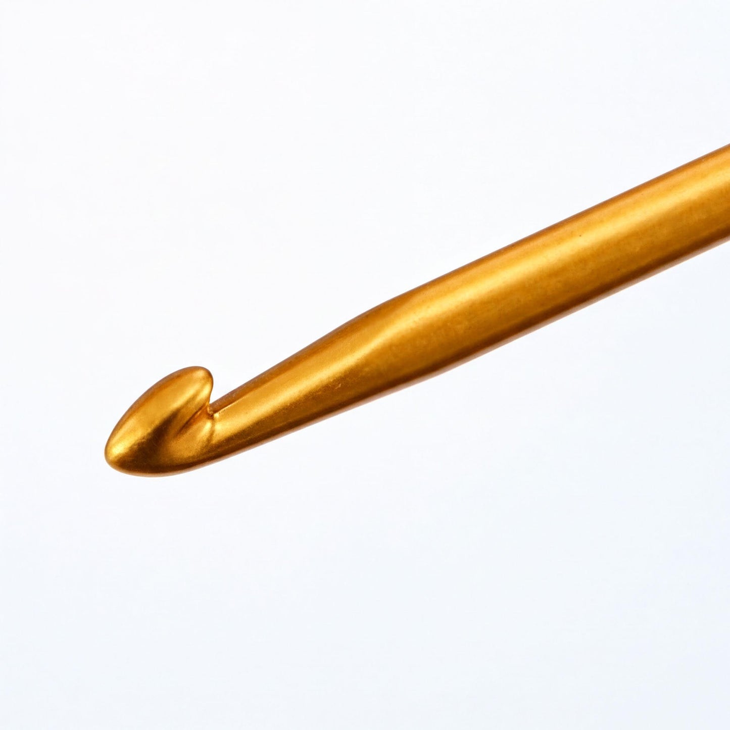 A close-up view of a gold crochet hook against a white background.