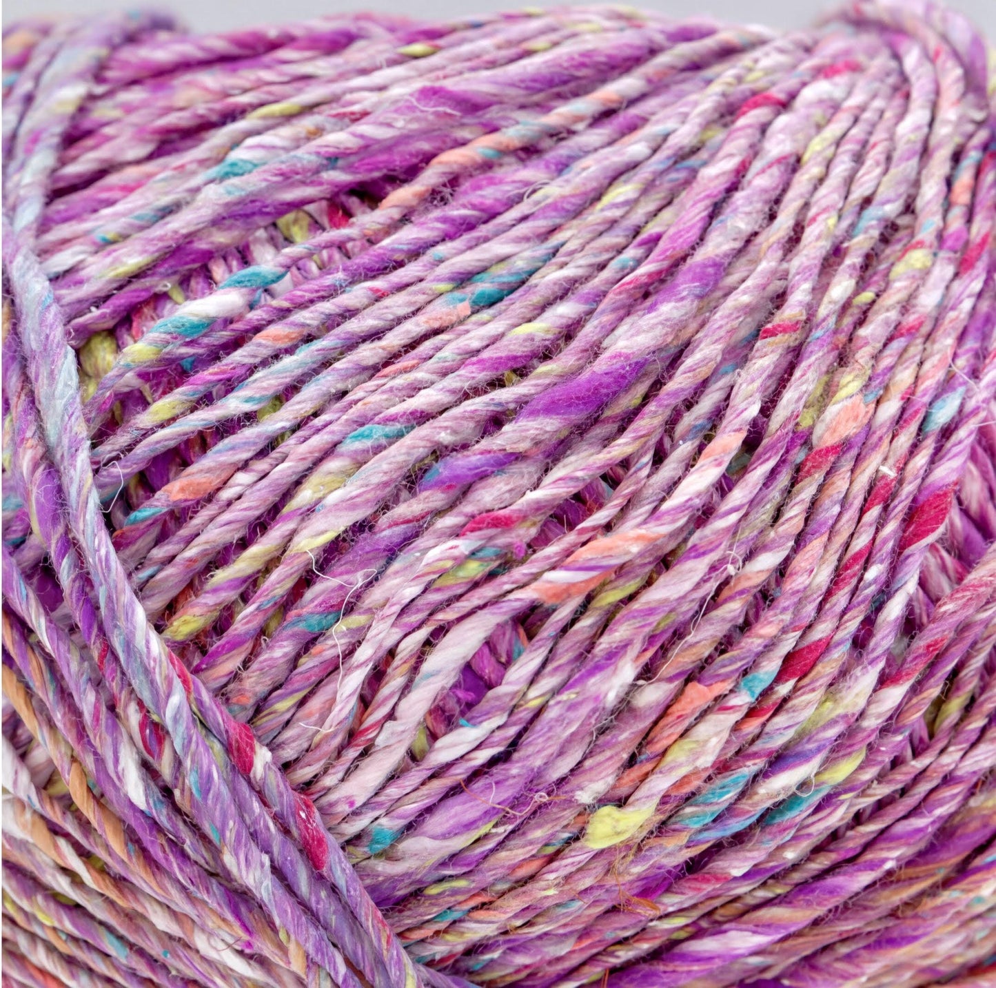 A close-up image of a ball of multicolored yarn, with the yarn's strands twisted and interwoven in a close-up view.