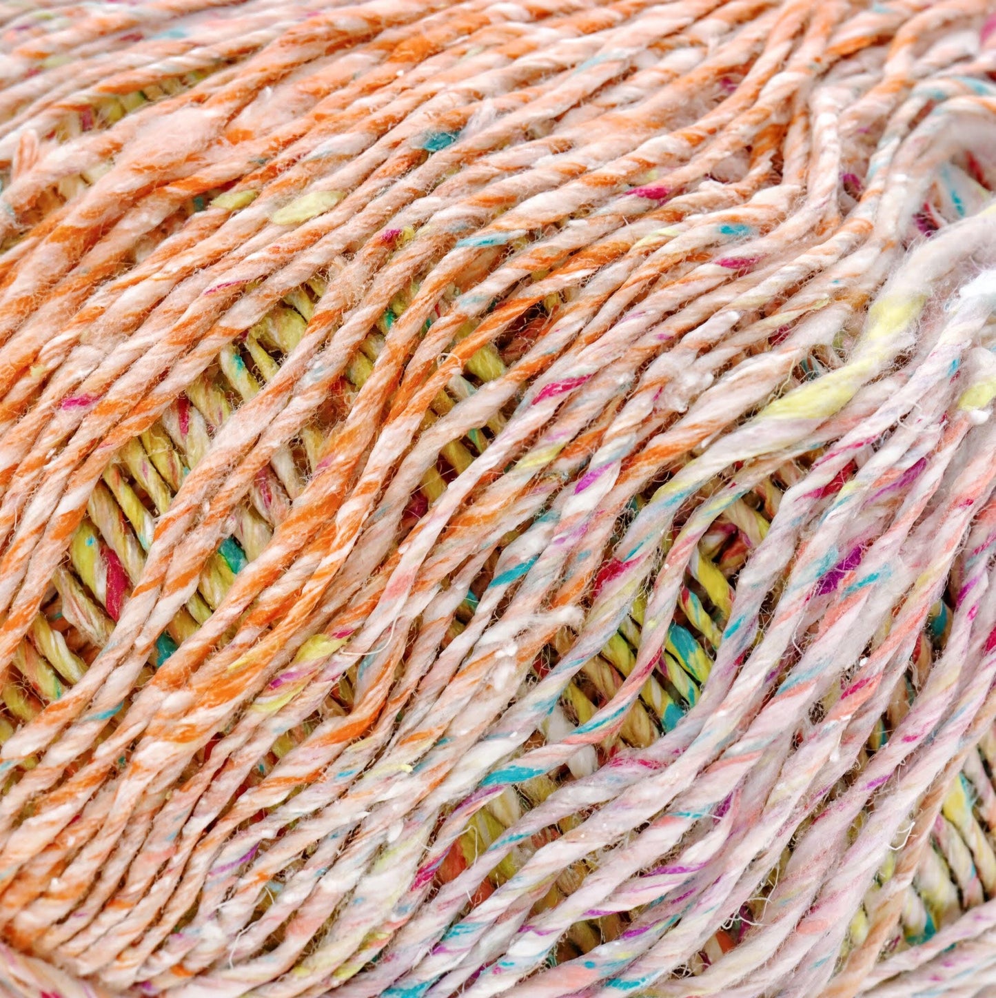 a close-up view of a ball of multicolored yarn, with the yarn's strands twisted and intertwined in a complex pattern.