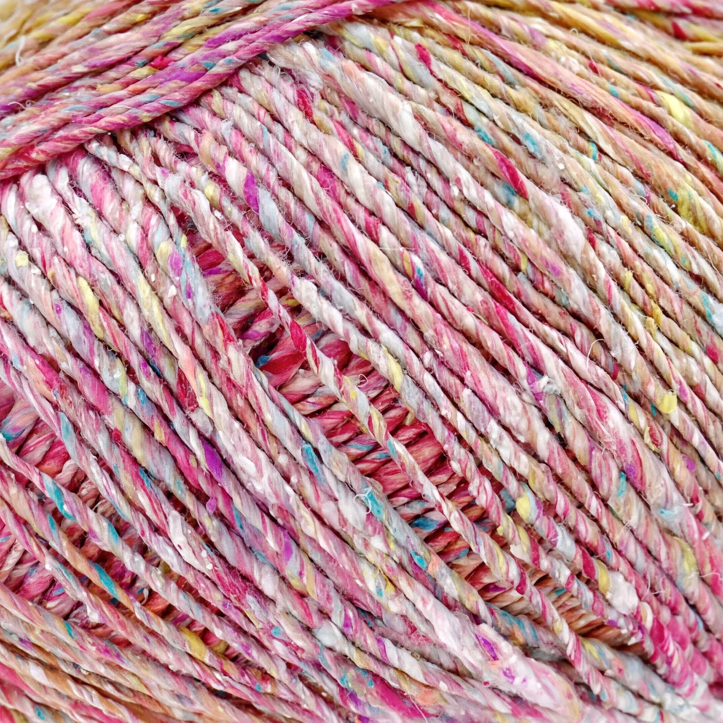A close-up image of a ball of multicolored yarn, with the yarn's strands twisted and interwoven in a crisscross pattern.