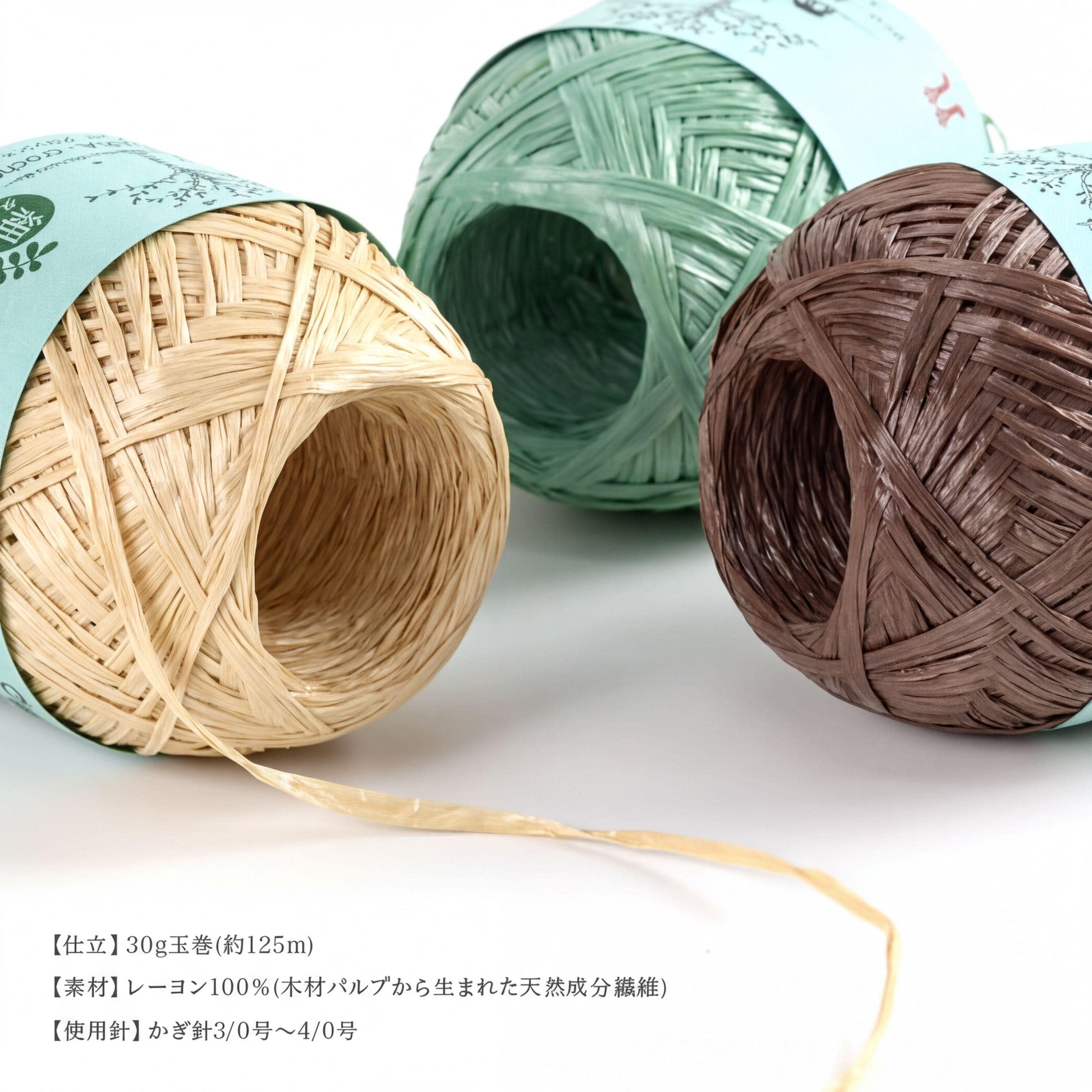 Three spools of thread in different colors - beige, green, and brown - are displayed on a white background.