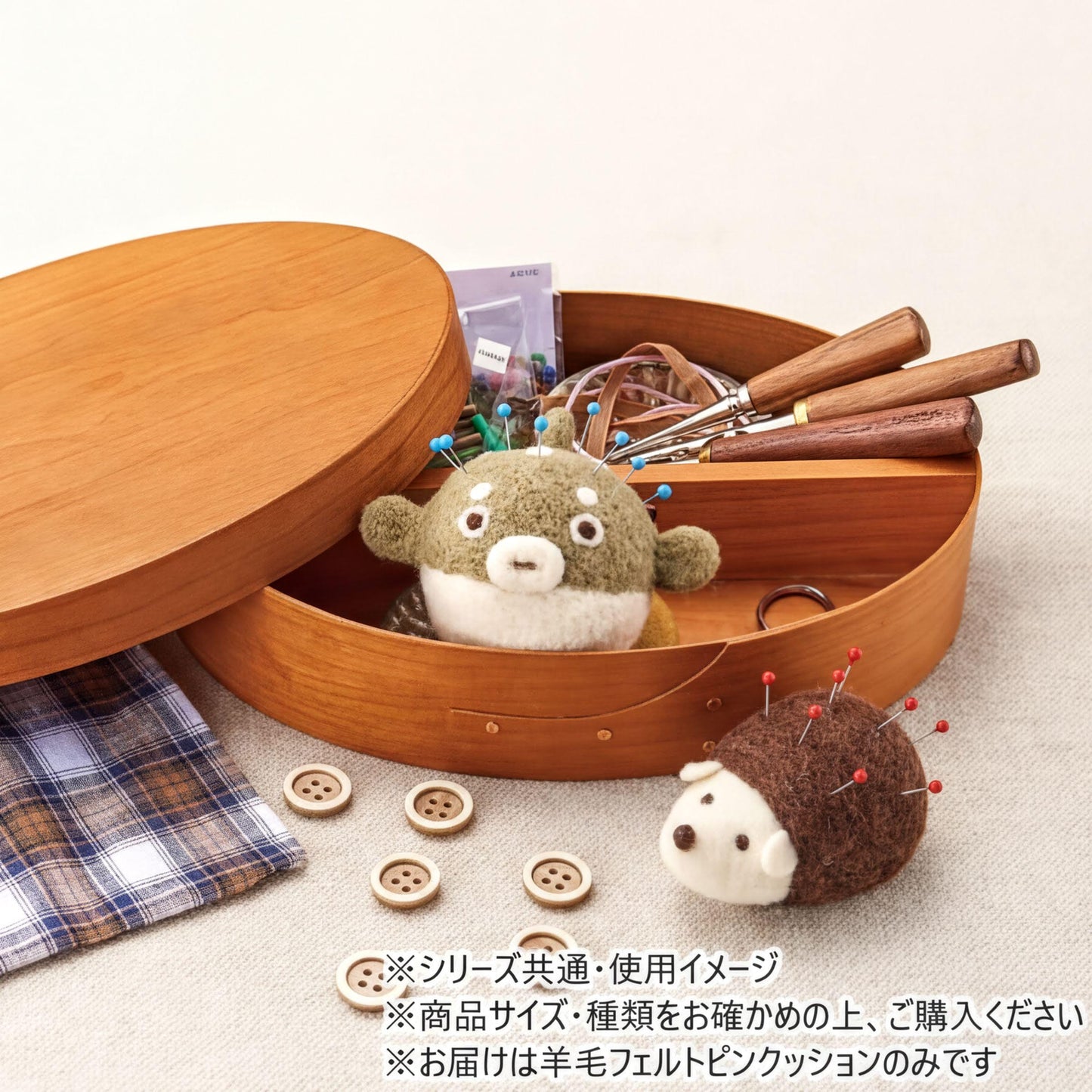 A wooden box containing various sewing and crafting supplies, including a stuffed animal, buttons, and a pair of scissors.