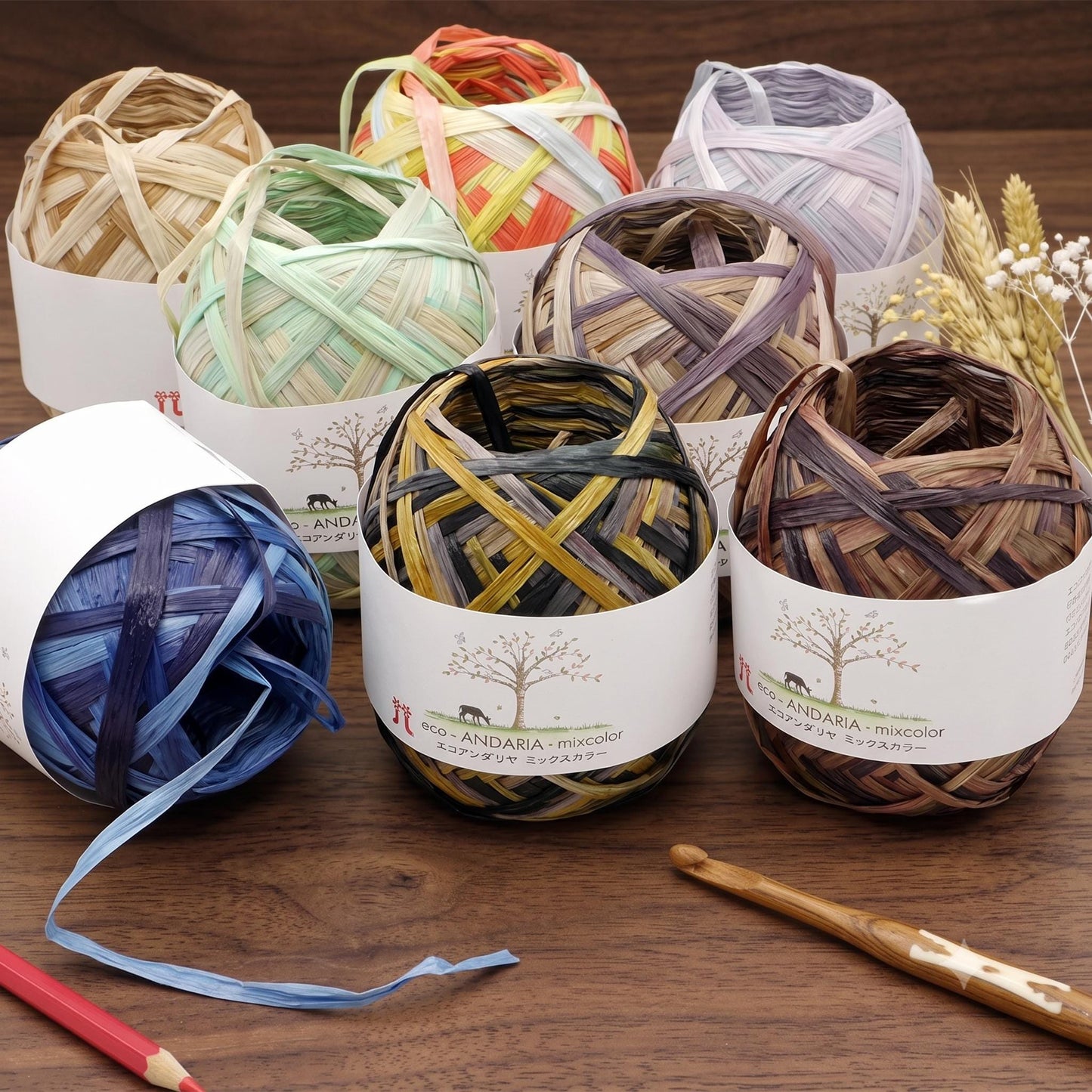 a variety of yarn balls and crochet hooks arranged on a wooden surface.