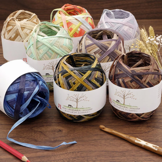 a variety of yarn balls and crochet hooks arranged on a wooden surface.