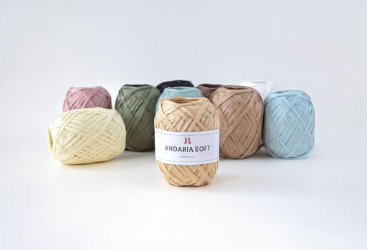 A collection of colorful spools of thread, including white, green, and brown, arranged on a white background.