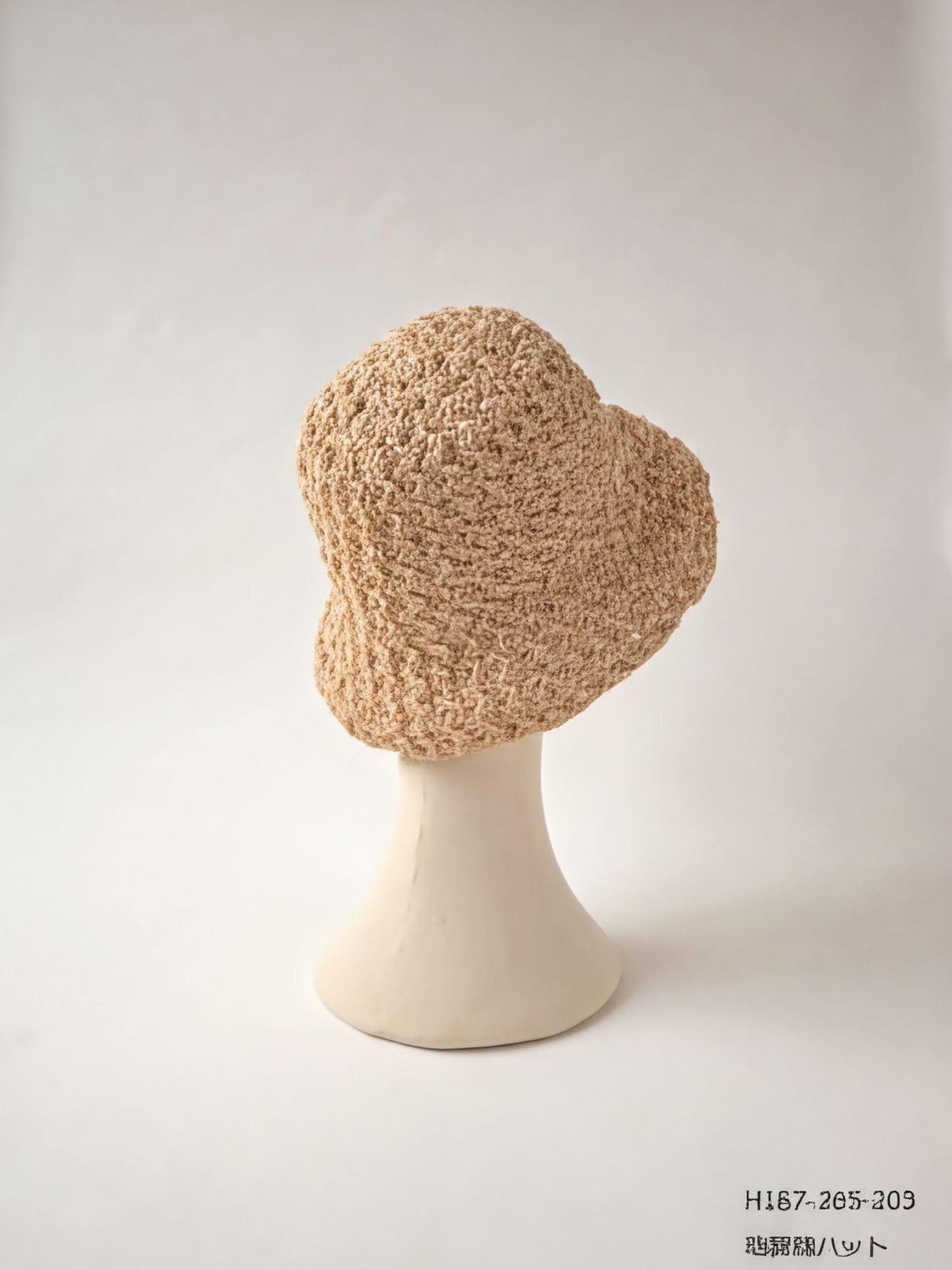 A beige crocheted hat is displayed on a white mannequin head against a plain white background.