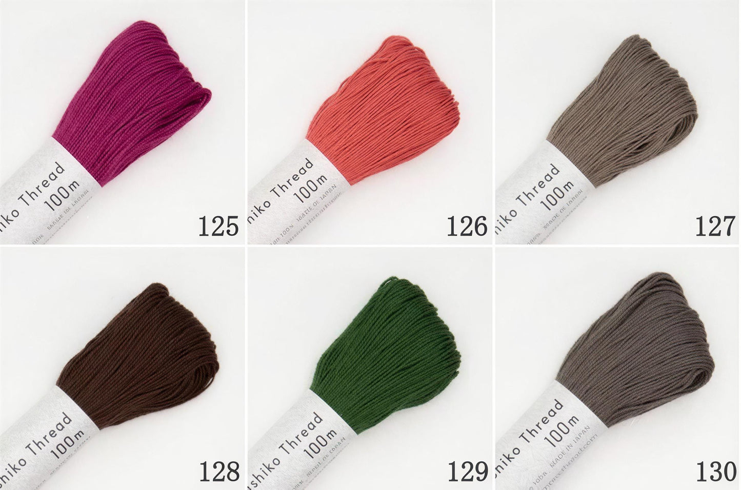 six different spools of thread in various colors, including pink, orange, green, brown, and gray.