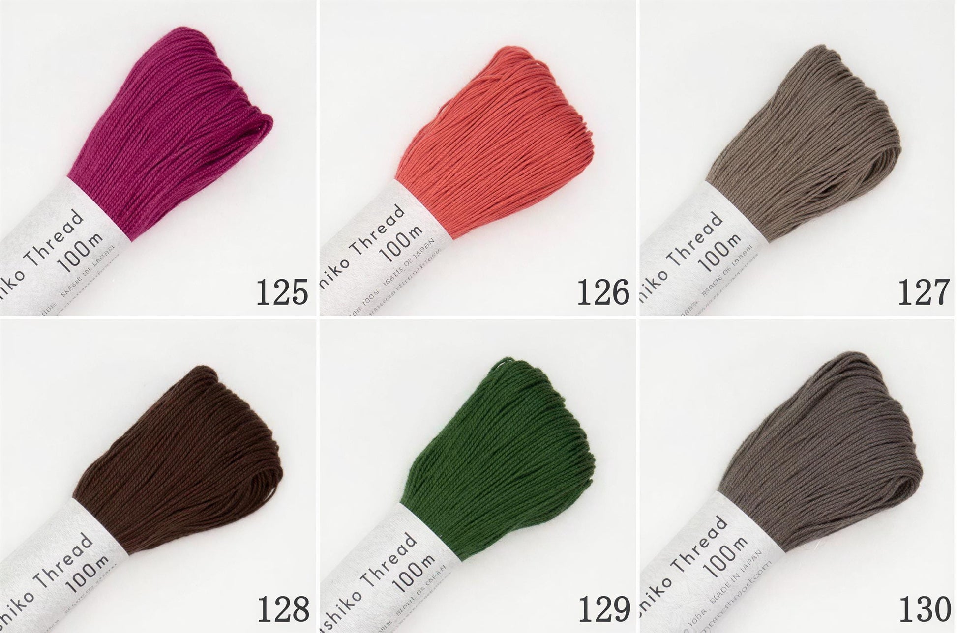 six different spools of thread in various colors, including pink, orange, green, brown, and gray.