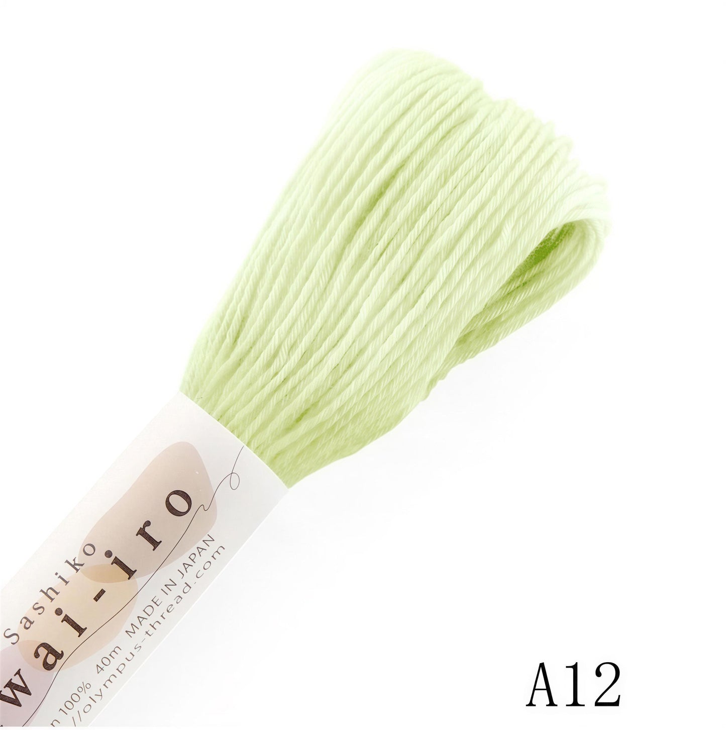 A spool of pale green thread is shown against a white background.