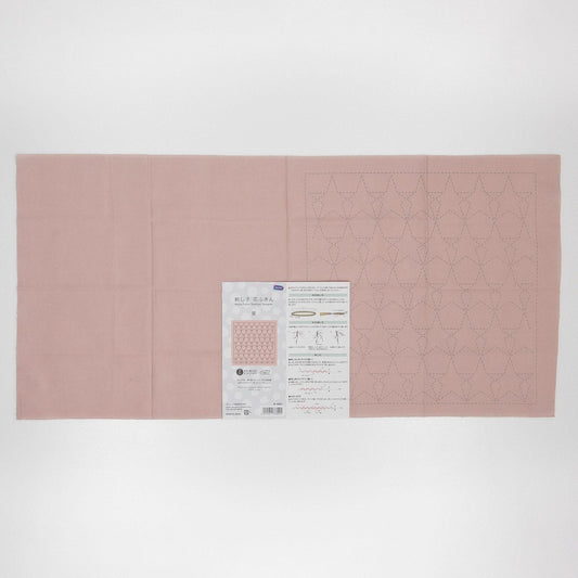 The image is a pink fabric with a pattern of small white dots or lines, and there is a printed paper with instructions or information about the fabric.