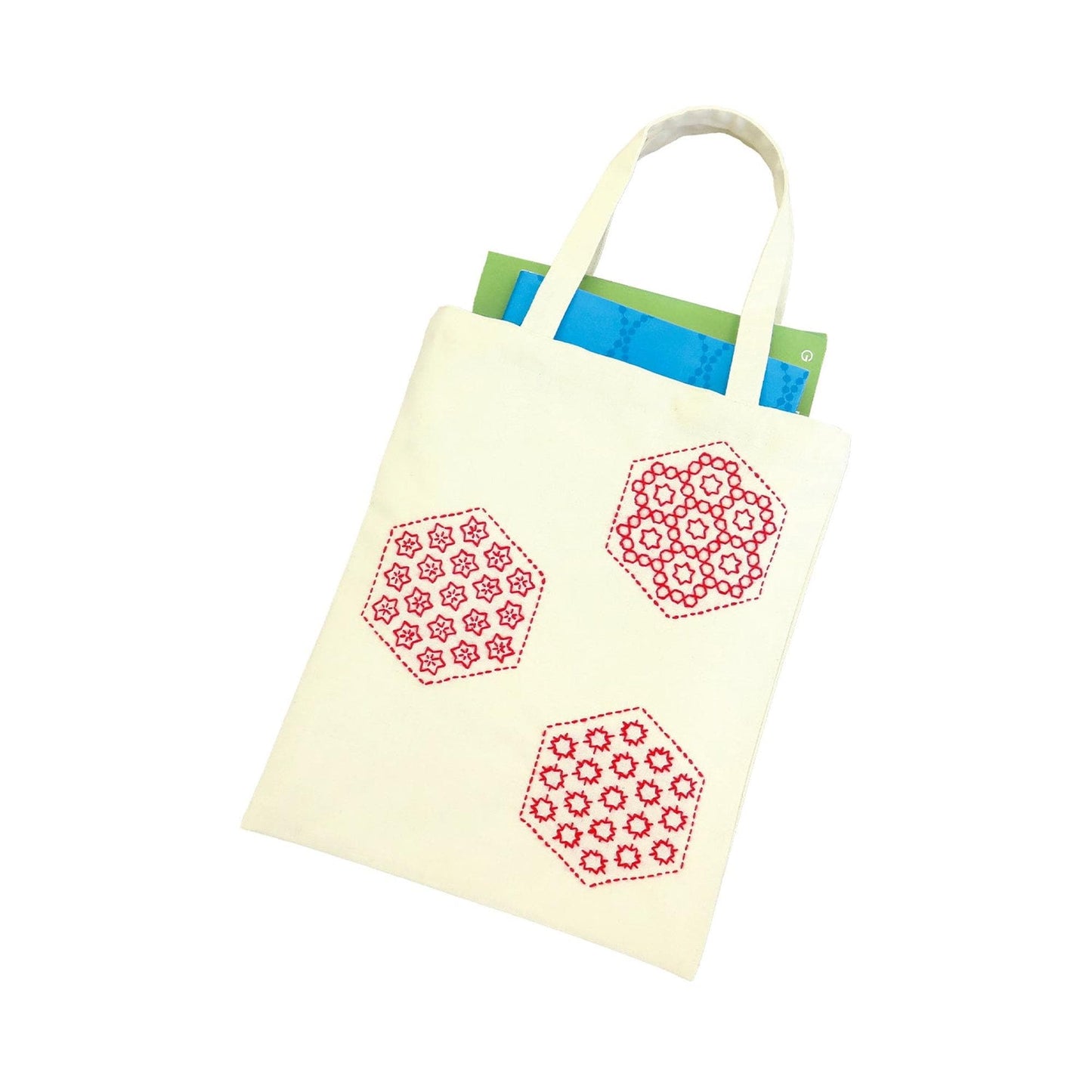 A white tote bag with red and green geometric patterns printed on it.