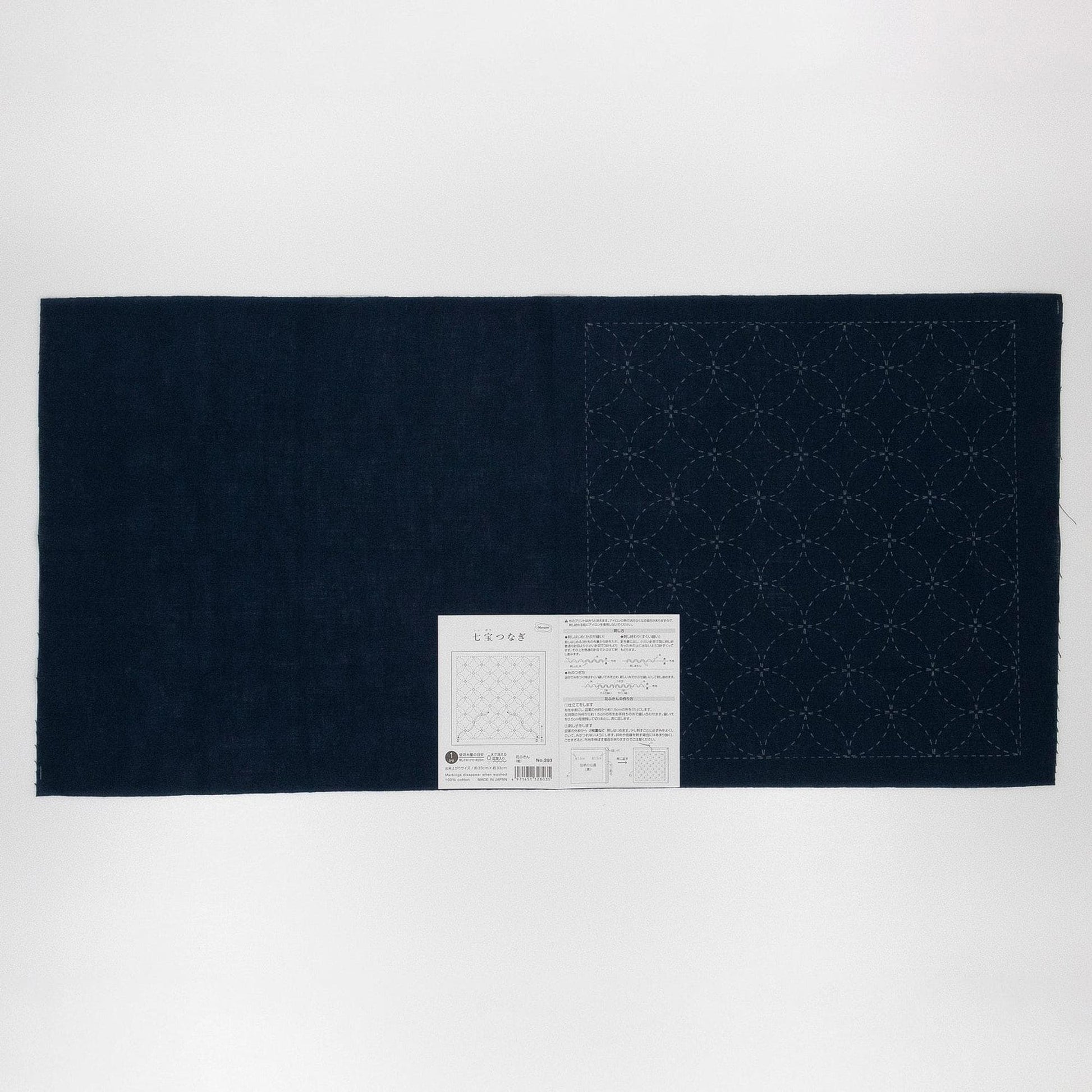 a dark blue fabric with a white label attached to it, which appears to be a piece of paper with instructions or information.