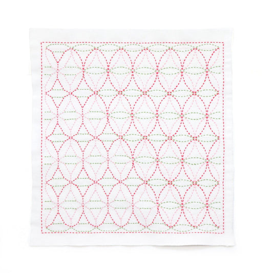 a square-shaped piece of fabric with a repeating pattern of red and green circles and lines, creating a visually striking and intricate design.