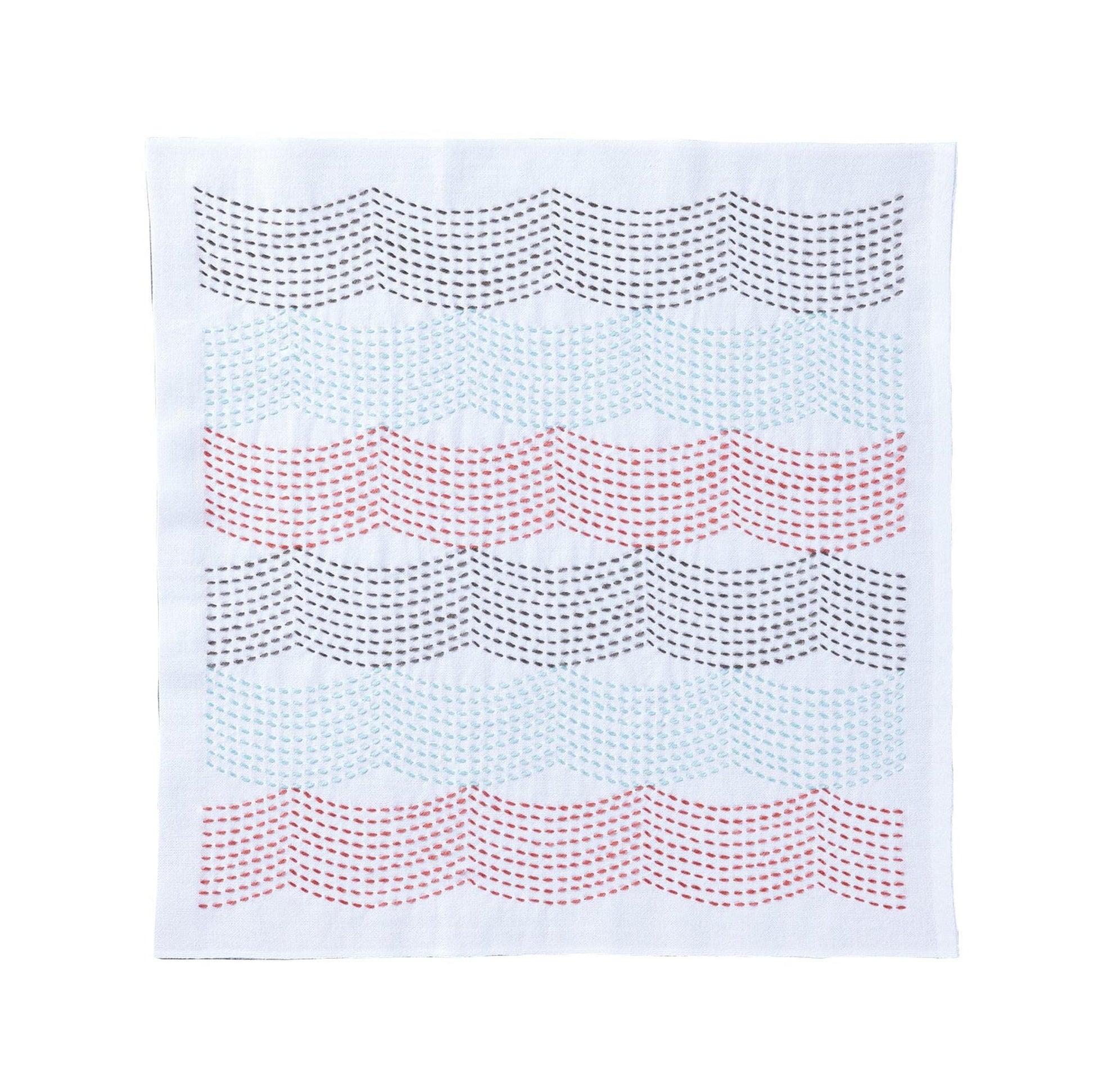 a white fabric with a repeating pattern of wavy lines in various colors, including red, blue, and gray.