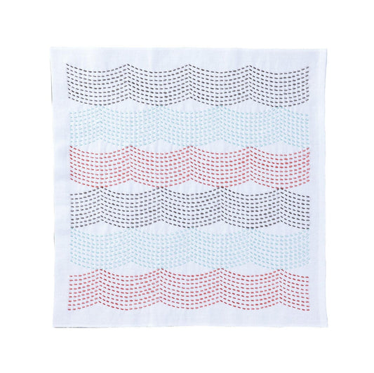 a white fabric with a repeating pattern of wavy lines in various colors, including red, blue, and gray.