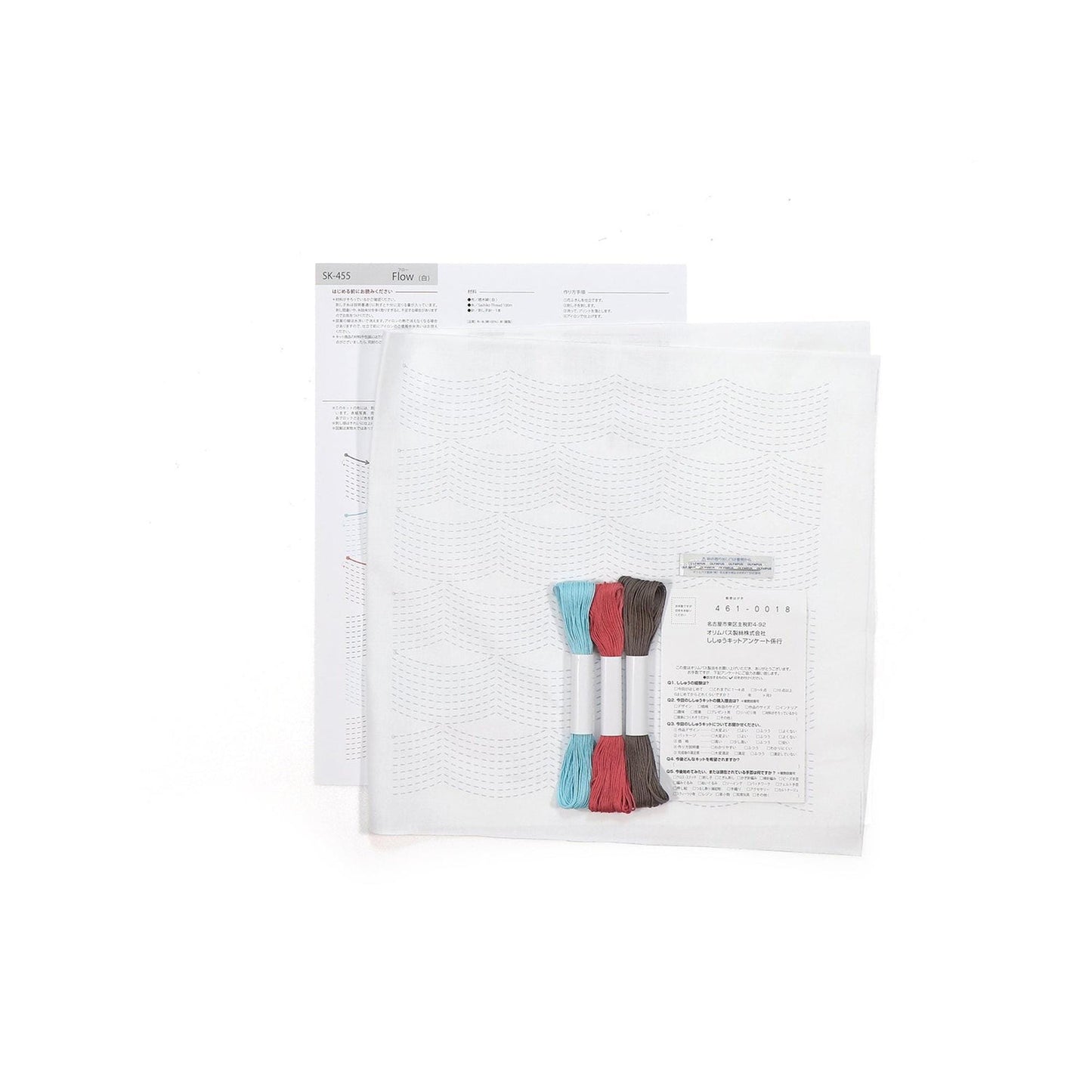 a white paper with text and a small package containing a pair of embroidery floss.