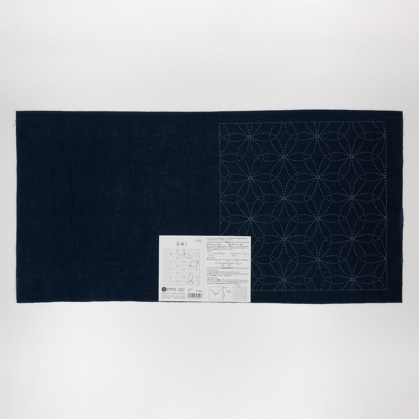 a dark blue fabric with a white label attached to it, which appears to be a sewing pattern or instructions.