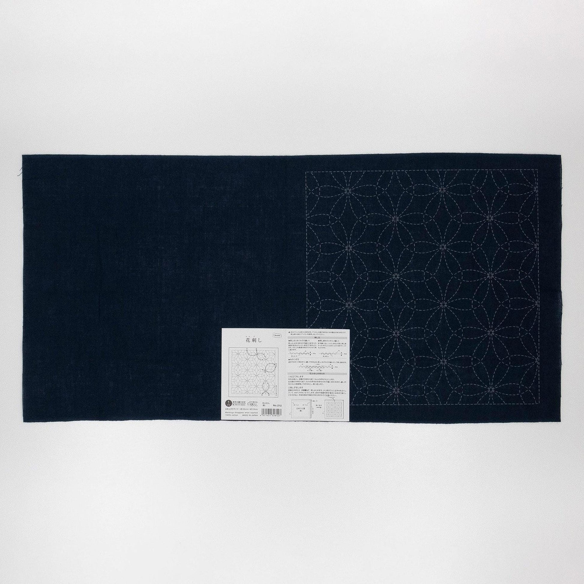 a dark blue fabric with a white label attached to it, which appears to be a sewing pattern or instructions.