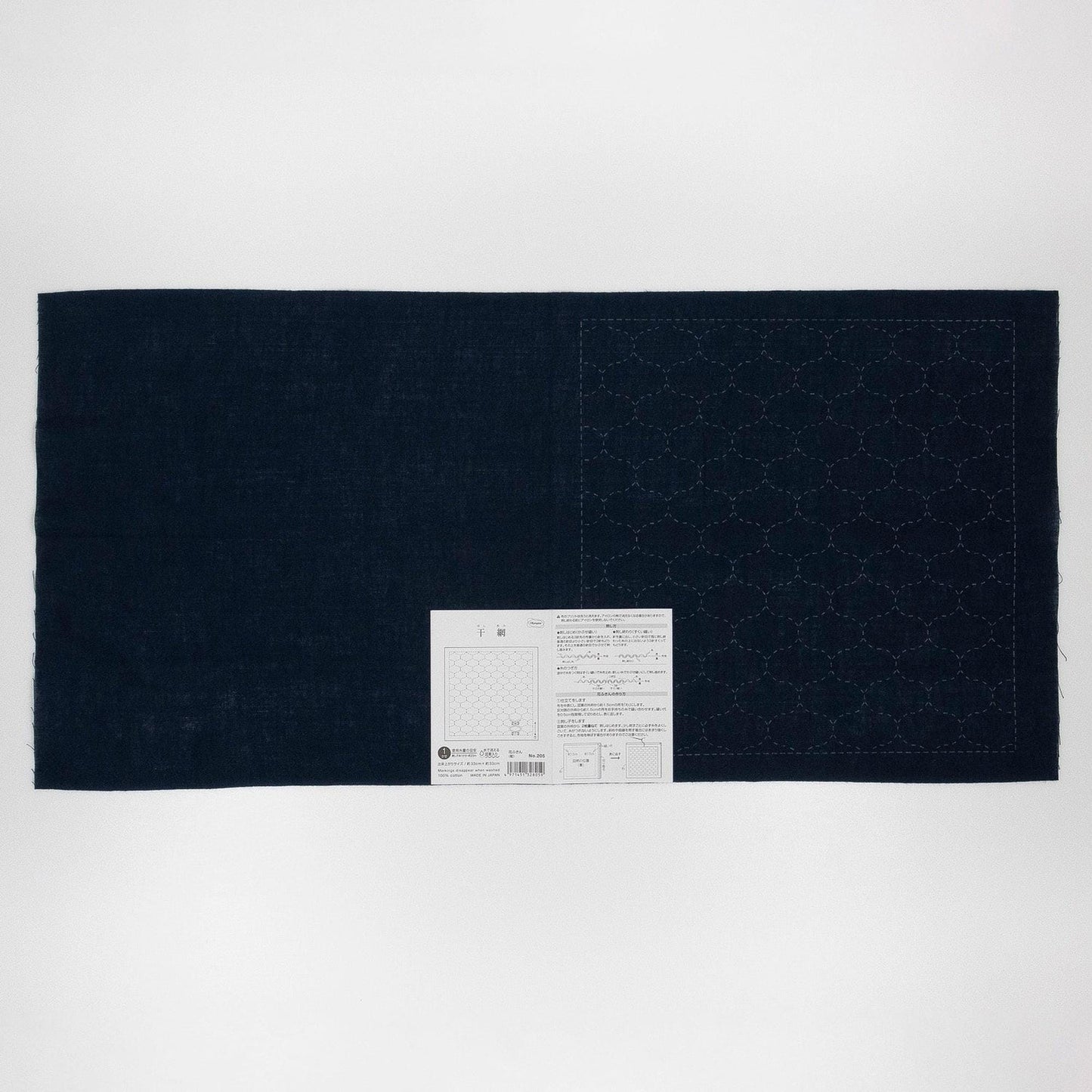 a dark blue fabric with a white label attached to it, placed against a white background.