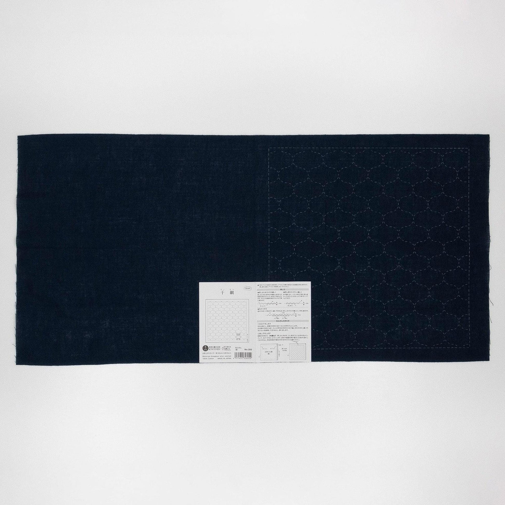 a dark blue fabric with a white label attached to it, placed against a white background.