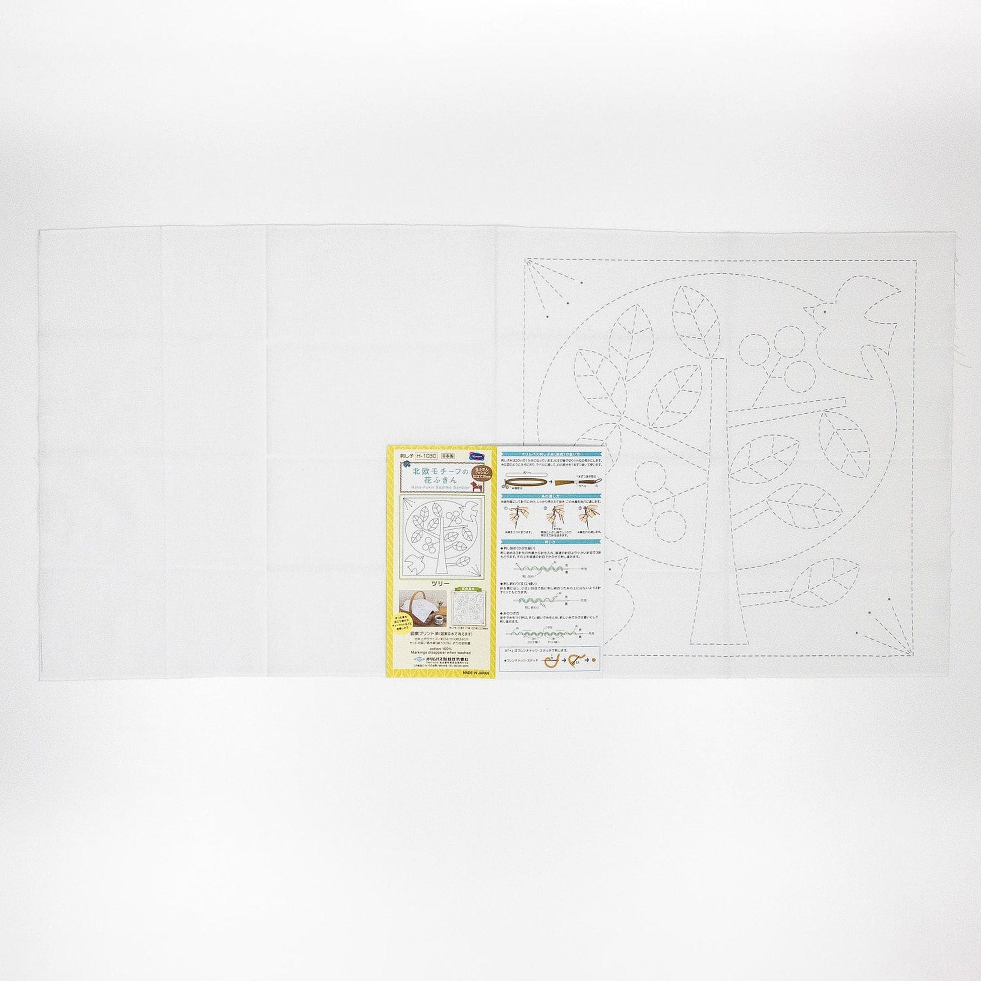The image is a white sheet of paper with a tree drawing and some text, along with a yellow and white label.