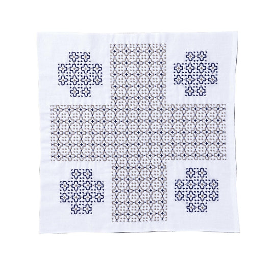 a square piece of fabric with a repeating pattern of small blue and white shapes, creating a visually striking design.
