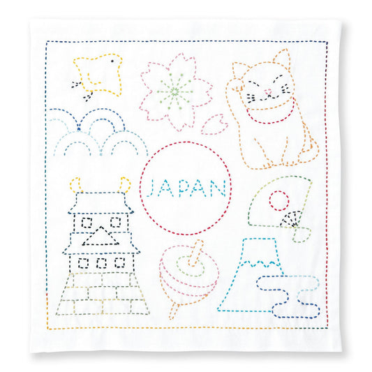 The image is a colorful embroidery or needlepoint design featuring various Japanese-themed elements, including a cat, a bird, a flower, and a temple. The word "JAPAN" is prominently displayed in the center of the design.
