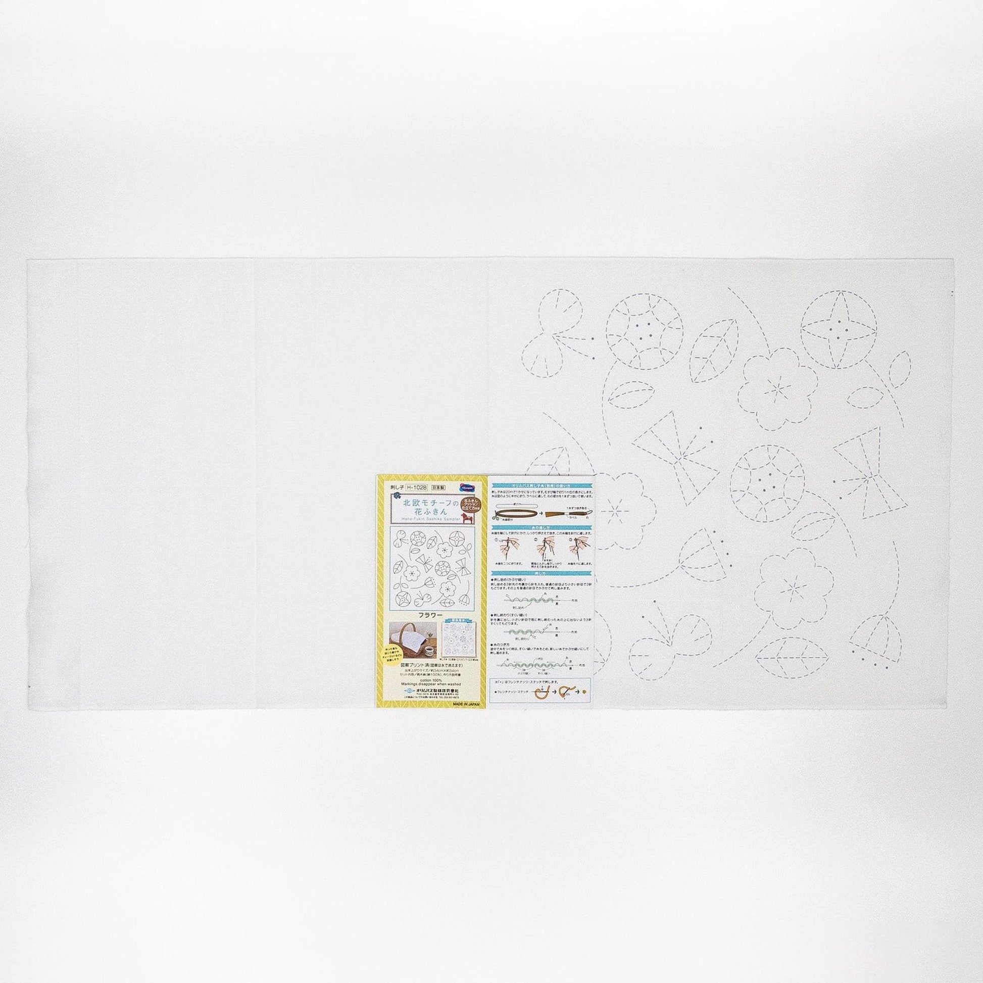 The image is a white sheet of paper with various patterns and designs, including flowers and leaves, as well as some text and illustrations.