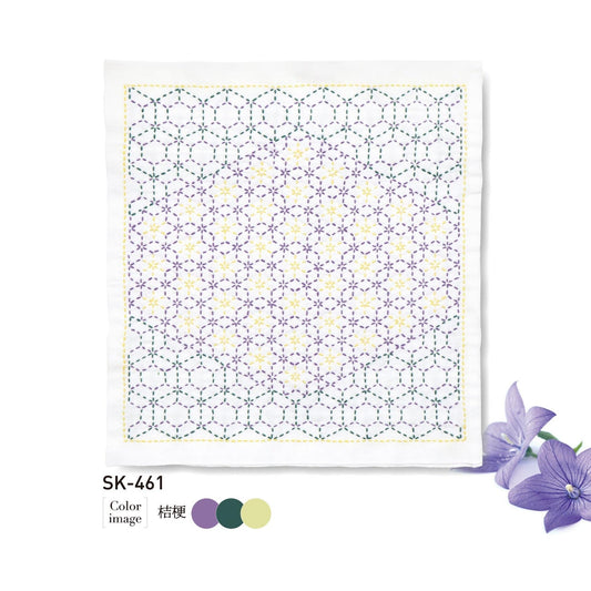 The image is a square with a geometric pattern of purple and yellow hexagons, and there are purple flowers next to it.