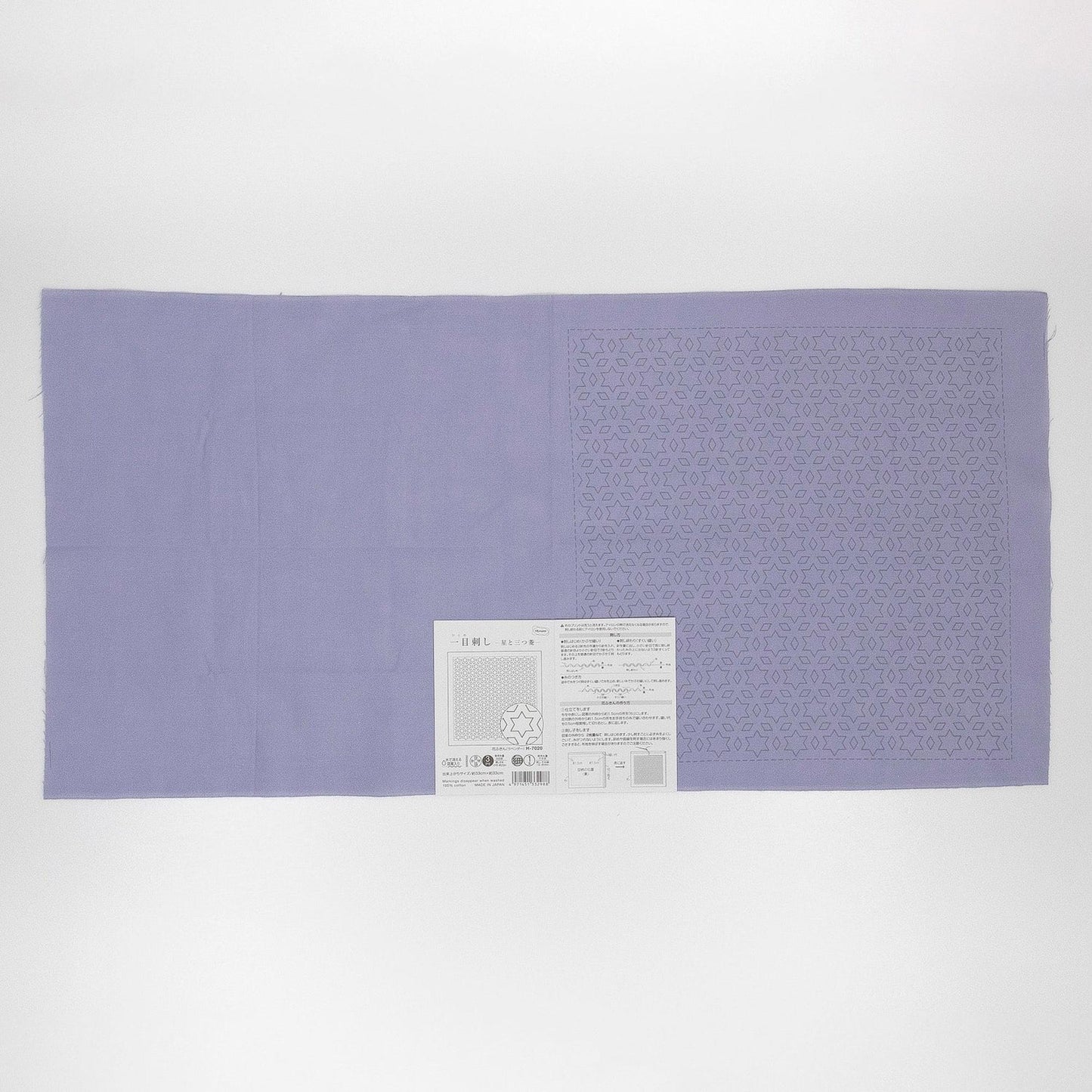 The image is a large purple fabric with a white label attached to it, which appears to be a piece of paper with text and possibly a barcode.