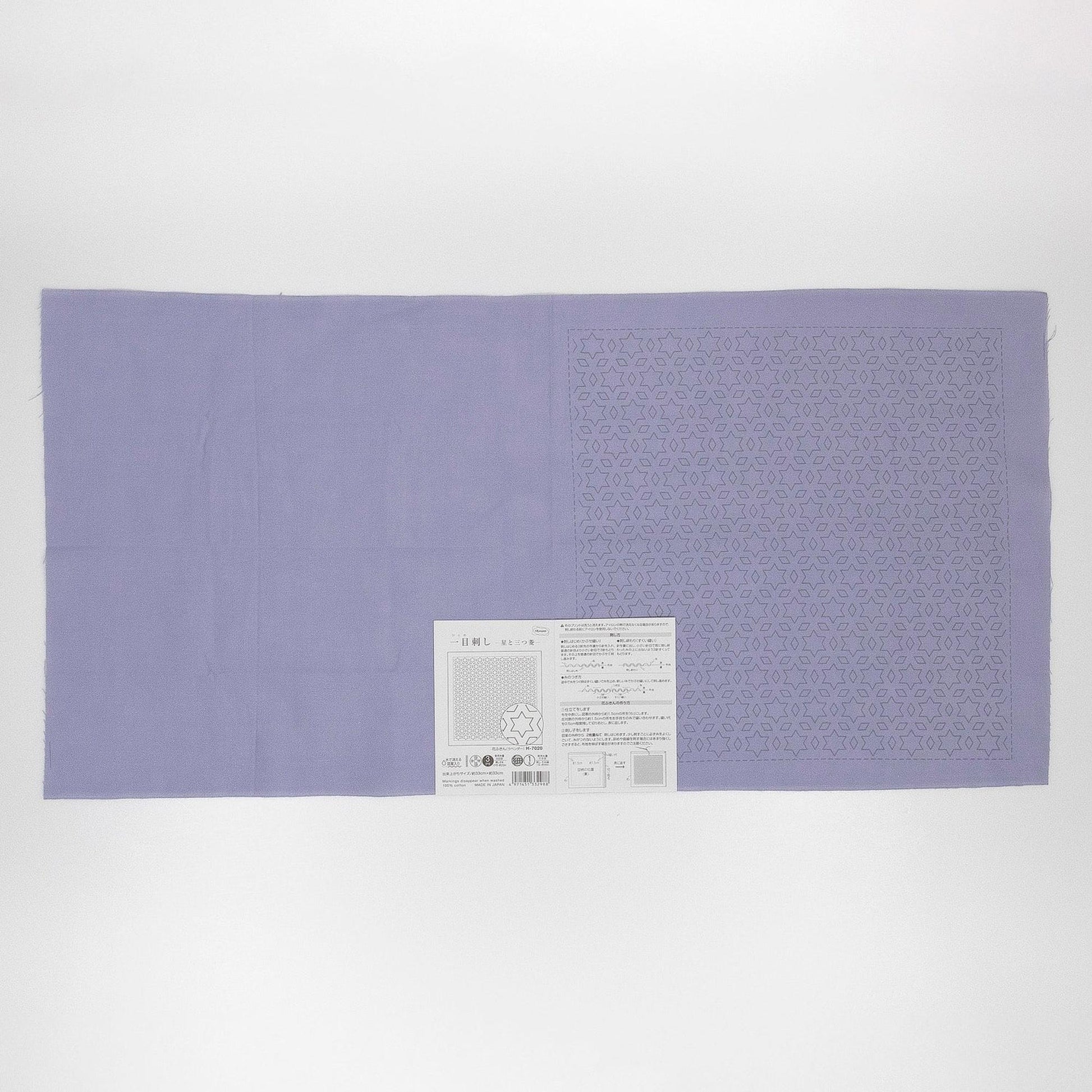 The image is a large purple fabric with a white label attached to it, which appears to be a piece of paper with text and possibly a barcode.