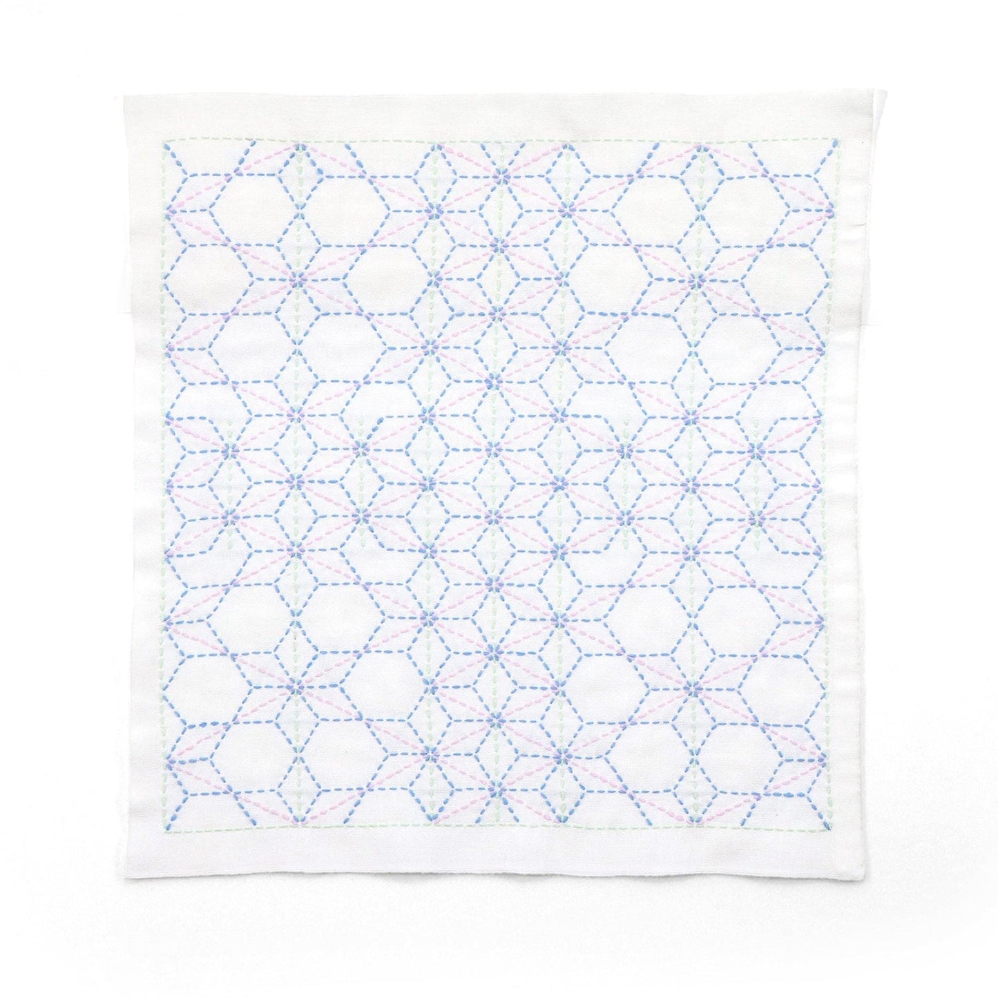 a white fabric with a repeating pattern of blue and pink hexagons.