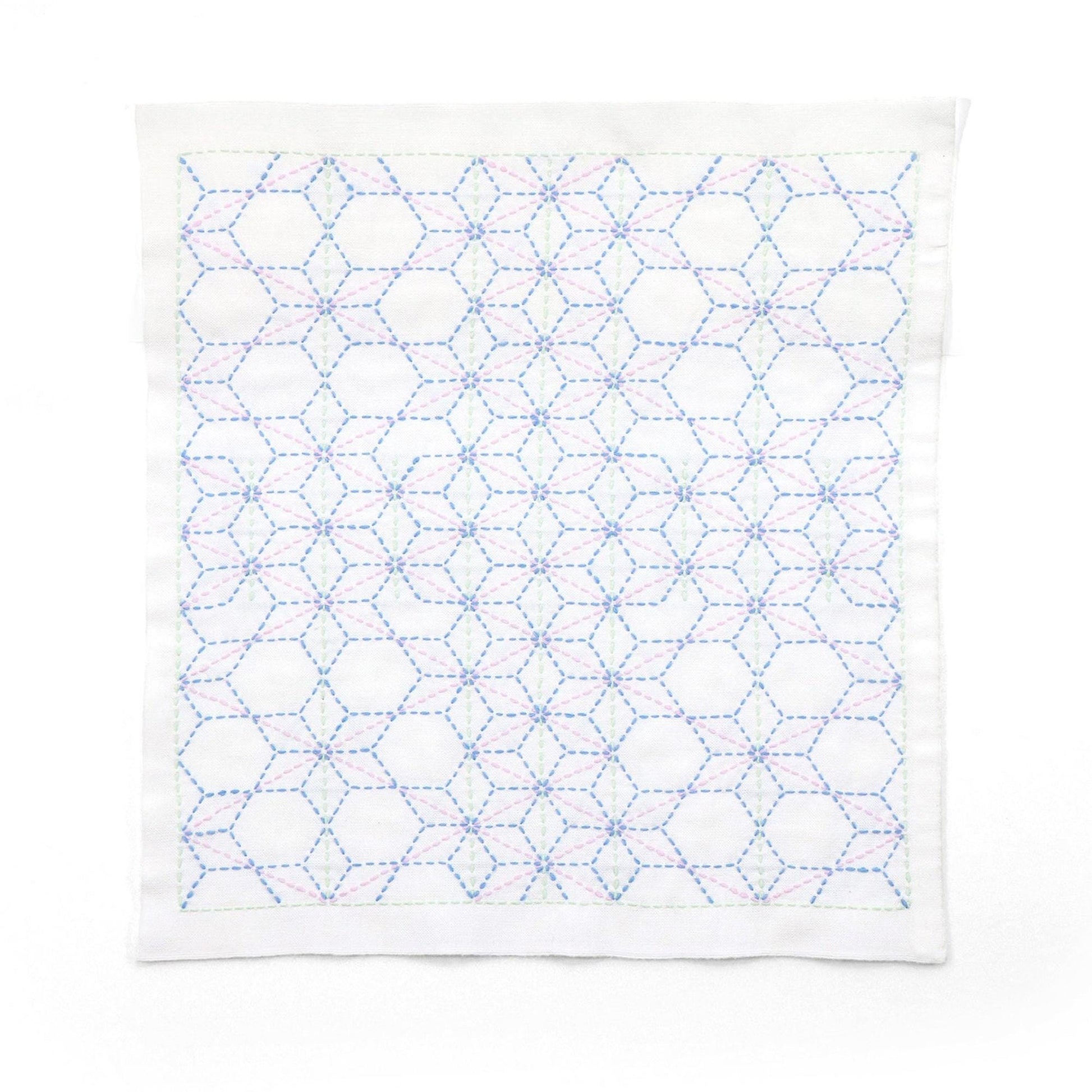 a white fabric with a repeating pattern of blue and pink hexagons.